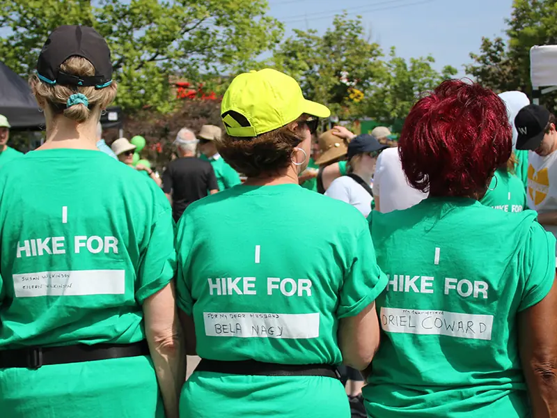 Three people with a green t-shirt that reads I hike for