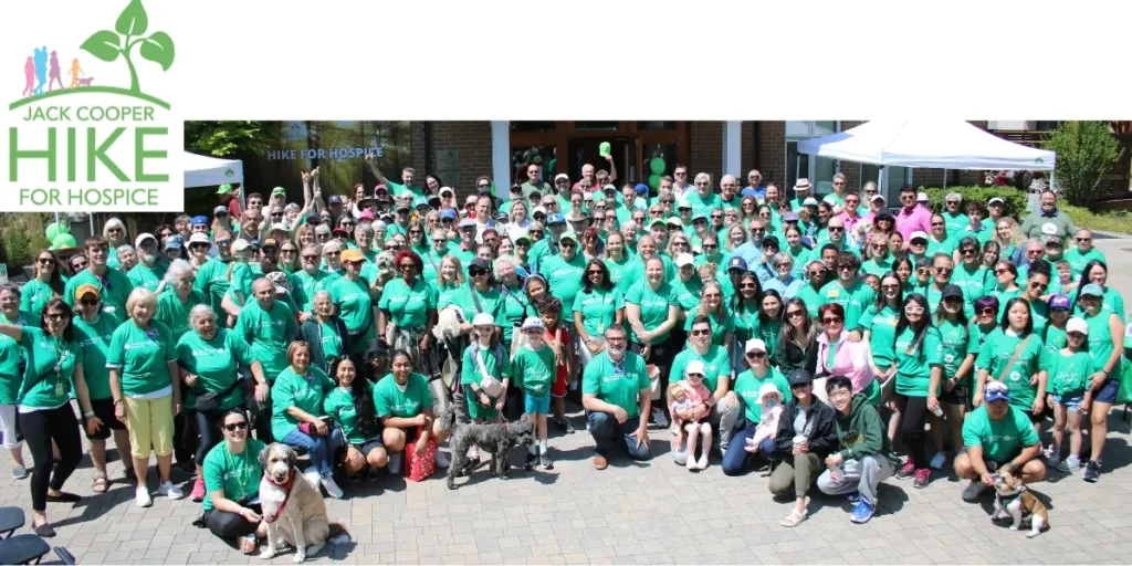 A group photo in front of the hospice residence of all attendees of the 2024 Jack Cooper Hike for Hospice
