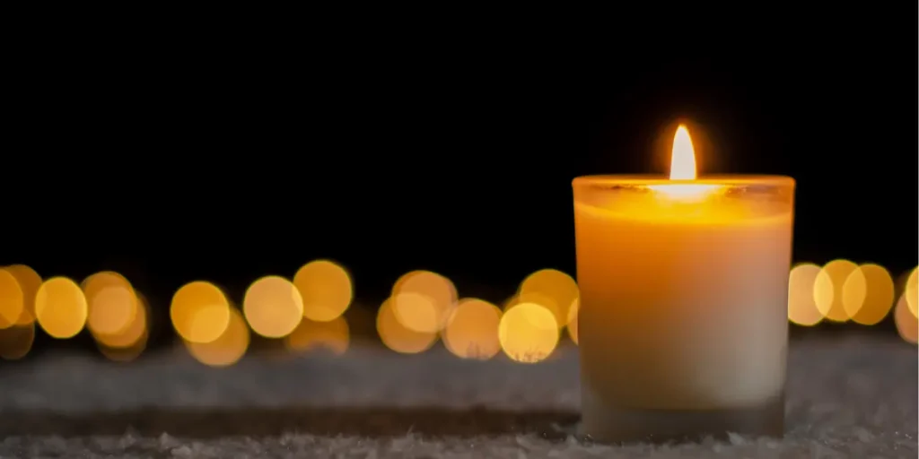 A lit candle against a dark background