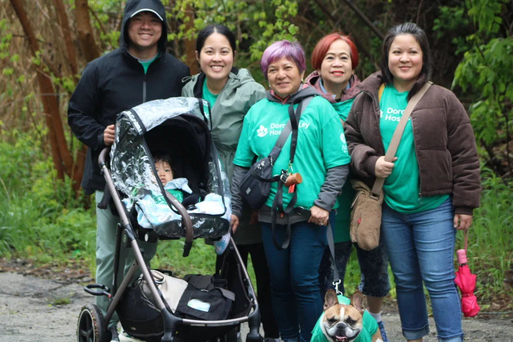 a photo of 6 family members wearing green t-shirts, a baby in a stroller, and a dog on a nature trail for the Jack Cooper hike for hospice.